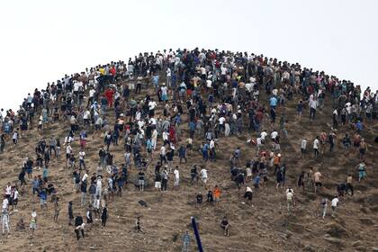 Un grupo de personas se reúne en una colina cercana al lugar donde se produjeron enfrentamientos cerca de Fnideq, en la frontera entre Marruecos y España, el 31 de julio de 2026. Miles de migrantes cruzaron durante la noche desde Marruecos hacia el enclave español de Ceuta, en el norte de África, según informó una fuente policial el 31 de julio
(Foto de Abdel Majid BZIOUAT / AFP)