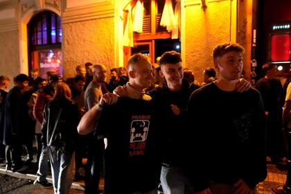 Un grupo de turistas forma una fila afuera de un pub en un recorrido de bares en el centro de Praga, República Checa, el jueves 17 de octubre de 2024. (AP Foto/Petr David Josek)