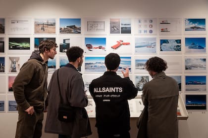 Un grupo de visitantes admirado ante el perfil rojo de una base española.