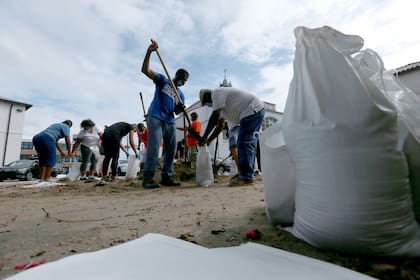 Un grupo de voluntarios llena sacos de arena para los residentes mientras la ciudad se prepara para el huracán Laura, en Nueva Orleans, Luisiana