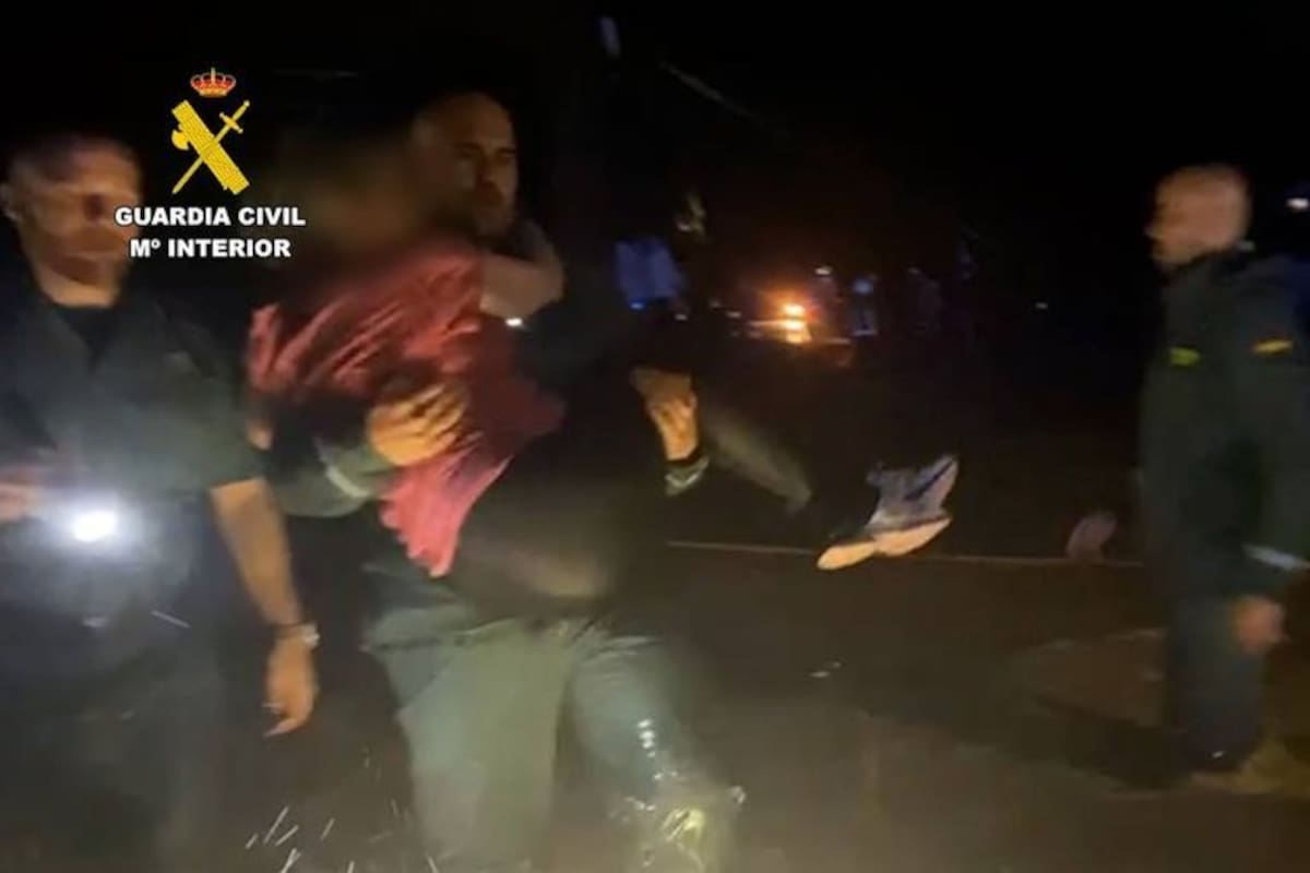 Un guardia civil, del equipo Roca de San Martín de Valdeiglesias, coge en brazos al niño de 10 años que sobrevivió una noche entera aferrado a una rama de árbol (crédito: Guardia Civil).