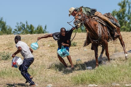 Un guardia fronterizo montado trata de detener a un migrante haitiano en Del Río, Texas