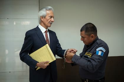 Un guardia le quita las esposas al premiado periodista José Rubén Zamora a su llegada a la sala de audiencias para el primer día de juicio contra él por cargos de lavado de dinero, en Ciudad de Guatemala, el martes 2 de mayo de 2023.