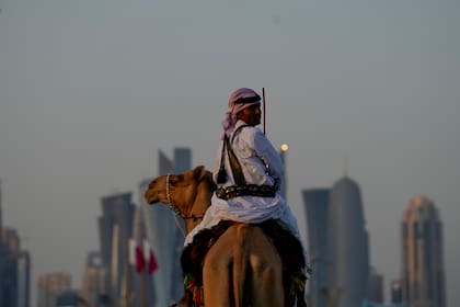 Un guardia monta su camello en las afueras del Amiri Diwan, las oficinas del emir de Qatar en Doha, el domingo 27 de noviembre de 2022