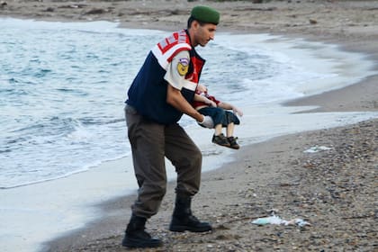 Un guardia turco recoge el cuerpo del menor que apareció tendido en una playa