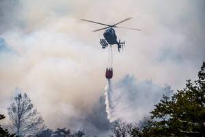 Un helicóptero arroja agua sobre las llamas que arrasan los bosques del Parque Nacional Lanín