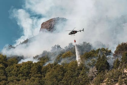 Un helicóptero con helibalde combate los incendios