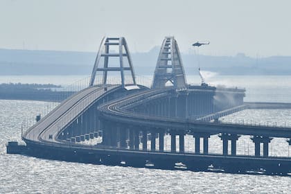 Un helicóptero deja caer agua para detener un incendio en el Puente de Crimea que conecta a Rusia con la península de Crimea, el 8 de octubre de 2022, en Kerch. (AP Foto, Archivo)