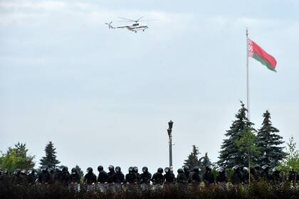 Un helicóptero que se cree que transporta al presidente bielorruso, Alexander Lukashenko, sobrevuela a los agentes frente al Palacio de la Independencia durante una manifestación de partidarios de la oposición para protestar contra los resultados de las elecciones presidenciales en disputa en Minsk