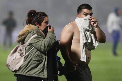 Un hincha de Gimnasia y Esgrima se protege el rostro con su remera