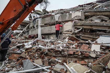 Un hombre busca sobrevivientes entre los escombros de un edificio tras un potente sismo, en Gaziantep, Turquía, el 6 de febrero de 2023. (AP Foto/Mustafa Karali)