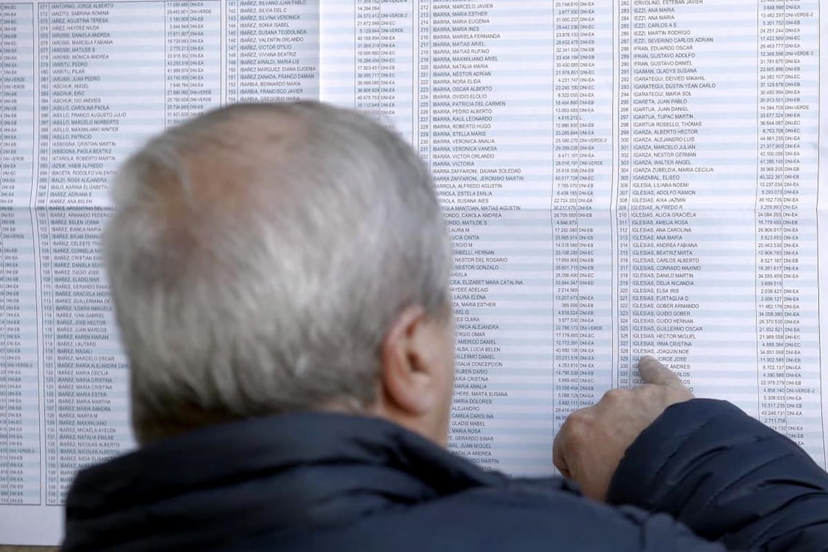Un hombre busca su mesa en un padrón de una escuela en Mar del Plata