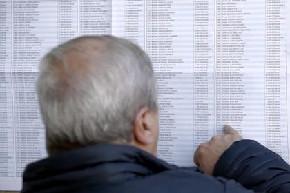 Un hombre busca su mesa en un padrón de una escuela en Mar del Plata
