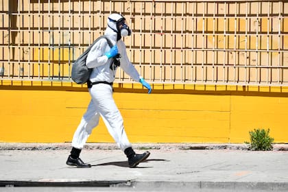 Un hombre camina el 15 de abril de 2020 por la calle en Los Ángeles, California con un traje protector para el coronavirus