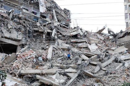 Un hombre camina entre los escombros de un edificio que se derrumbó en La Guaira, Venezuela, el 25 de junio de 2026