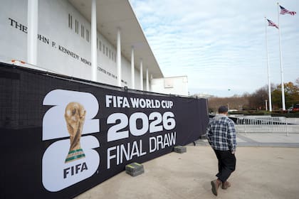 Un hombre camina frente a un cartel alusivo al sorteo del Mundial, el jueves 4 de diciembre de 2025, en el Centro Kennedy de Washington (AP Foto/Chris Carlson)