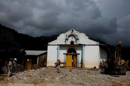 Un hombre camina frente a una iglesia local de Yucucani