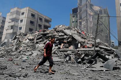 Un hombre camina por los escombros de un edificio destruido por un ataque de Israel en Gaza, el 16 de mayo de 2021. (AP Foto/Adel Hana)