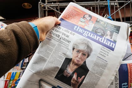 Un hombre compra la última edición del diario The Guardian en un quiosco de prensa, con una noticia de último momento sobre la primera ministra británica Theresa May: “Brexit retrasado dos años”