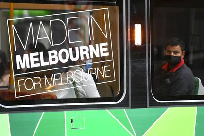 Un hombre con mascarilla en el tranvía en Melbourne