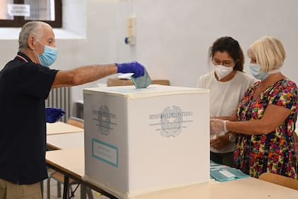 Un hombre con mascarilla y guantes emite su voto en un colegio electoral en el centro de Roma el 20 de septiembre de 2020