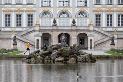 Un hombre corre frente al Palacio Nymphenburg en Múnich