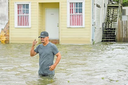 Un hombre cruza una calle inundada en Mandeville, Louisiana