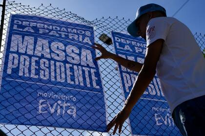 Un hombre cuelga un cartel de campaña promocionando al candidato presidencial Sergio Massa en las afueras de Buenos Aires, Argentina, el miércoles 8 de noviembre de 2023. El ministro de Economía argentino se enfrentará a Javier Milei en una segunda vuelta electoral el 19 de noviembre. (Foto AP/Natacha Pisarenko)