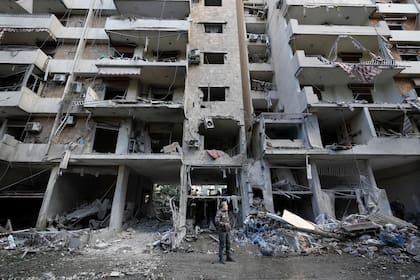 Un hombre de pie frente a un edificio destruido luego de un ataque aéreo israelí, el lunes 25 de noviembre de 2024, en Dahiyeh, un suburbio del sur de Beirut, Líbano. (AP Foto/Hussein Malla)