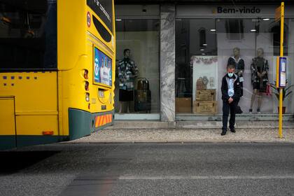 Un hombre de pie junto a una parada de autobús en Lisboa, Portugal, el 28 de octubre de 2021. (AP Foto/Armando Franca)