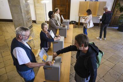 Un hombre deposita su voto durante las elecciones federales suizas en Delemont, Suiza, el domingo 22 de octubre de 2023.