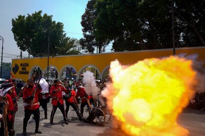 Un hombre dispara un cañón durante la recreación de la Batalla de Puebla, dentro de los actos para conmemorar el Cinco de Mayo en el vecindario de Peñón de los Baños, en la Ciudad de México, el 5 de mayo de 2022. (AP Foto/Eduardo Verdugo)