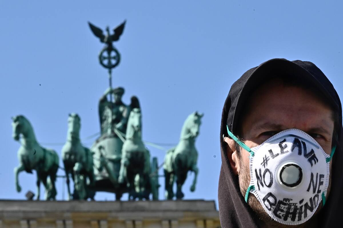 Un hombre en Berlín utiliza un barbijo que tiene escrita la frase: "No dejar a nadie atrás"