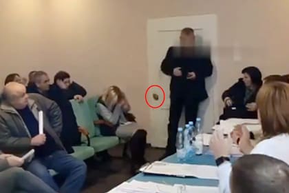 Un hombre entró a una habitación durante una reunión y unos segundos más tarde, sacó granadas de sus bolsillos y las arrojó al suelo, seguidas de explosiones posteriores.