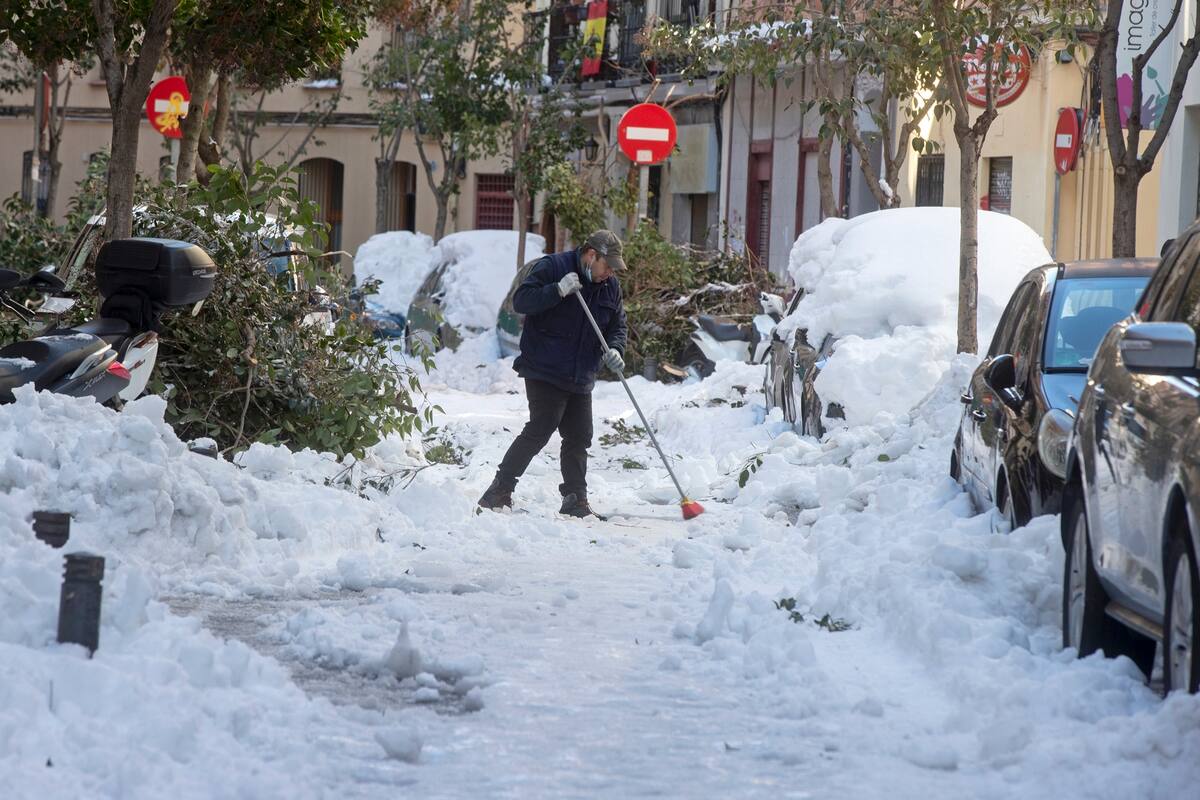 Un hombre intenta barrer la nieve de las calles en Madrid