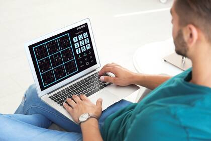 Un hombre jugando al sudoku en una computadora
