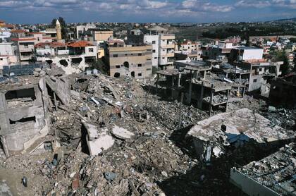 Un hombre junto a edificios destruidos tras regresar al pueblo de Qana, en el sur del Líbano, el jueves 28 de noviembre de 2024 tras el alto el fuego entre Israel y Hezbollah que entró en vigor el miércoles