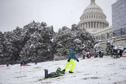 Un hombre lleva a su hijo en un trineo frente al Capitolio de Washington
