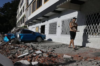 Un hombre lleva a su perro en brazos tras el terremoto que golpeó a Cali (AP Photo/Santiago Saldarriaga)
