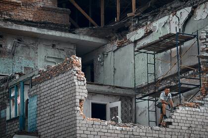 Un hombre mira desde un apartamento destruido por un ataque ruso en Nikopol, el lunes 15 de agosto de 2022.  (AP Foto/Kostiantyn Liberov)