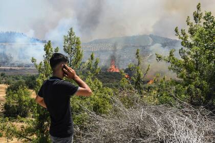 Un hombre mira los incendios forestales en un pueblo de Kacarlar cerca de la población costera mediterránea de Manavgat, Antalya, Turquía, el sábado 31 de julio de 2021. (AP Foto)