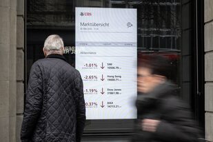 Un hombre mira un tablero de mercado en la sede del gigante bancario suizo UBS en Zúrich el 20 de marzo de 2023. (Fabrice COFFRINI / AFP)