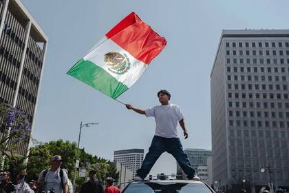 Un hombre ondea la bandera mexicana en las protestas en Los Ángeles.