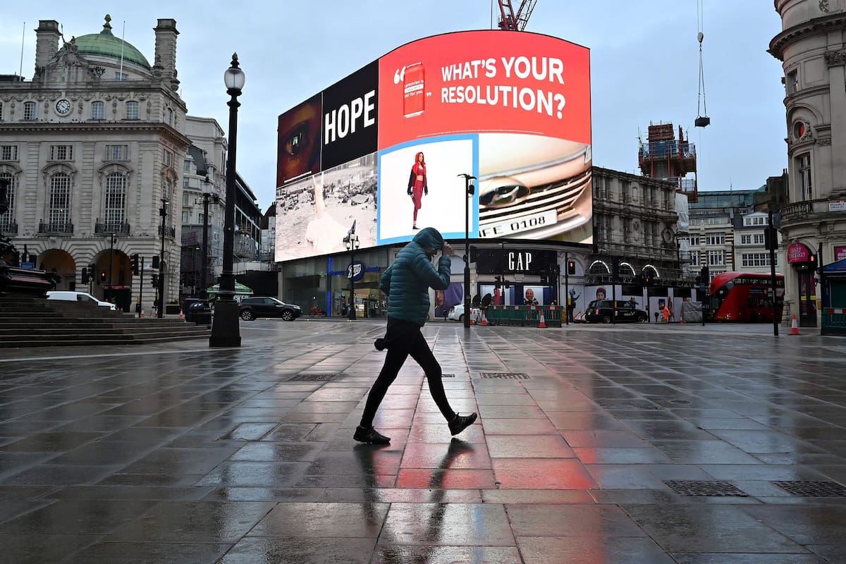 Un hombre pasa caminando por Piccadilly Circus, en Londres