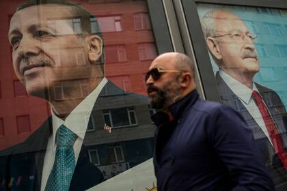 Un hombre pasa junto a carteles electorales del presidente de Turquía y candidato a la reelección de la Alianza Popular, Recep Tayyip Erdogan, a la izquierda, y el líder del partido CHP y candidato de la Alianza Nacional, Kemal Kilicdaroglu, en Estambul, el viernes 5 de mayo de 2023 en Estambul, Turquía.