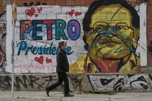 Un hombre pasa junto a un mural que representa al candidato presidencial de izquierda colombiano Gustavo Petro en Bogotá  (Foto Juan BARRETO / AFP)