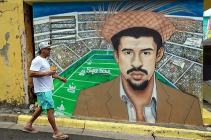 Un hombre pasa junto a un mural que representa al artista puertorriqueño Bad Bunny, pintado por los artistas locales Antonio Rodríguez y Alexis Villanueva, en el barrio La Perla de San Juan, Puerto Rico, antes del espectáculo de medio tiempo del Super Bowl, el 8 de febrero de 2026