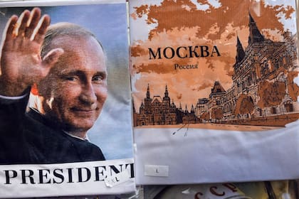 Un hombre pasa junto a una camiseta con una imagen del presidente ruso Vladimir Putin en una tienda de regalos en el centro de Moscú el 6 de octubre de 2022, en la víspera del 70º cumpleaños de Vladimir Putin.