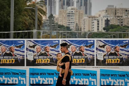 Un hombre pasa junto a una pancarta de campaña del partido Likud con la imagen del primer ministro israelí Benjamin Netanyahu y el presidente estadounidense Donald Trump, y un mensaje en hebreo que dice: "Tenemos una oportunidad para ganar"