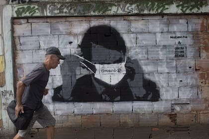 Un mural con el rostro del presidente Bolsonaro cubierto con barbijo